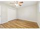 Bedroom featuring wood flooring, a ceiling fan, a window, and a large closet at 6071 Cristie Dr, Ellenwood, GA 30294