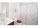 Clean bathroom with a shower curtain, white sink, and a wood-accented toilet seat at 248 Allegrini Dr, Atlanta, GA 30349