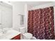 Bright bathroom with a cherry vanity, large mirror, and decorative shower curtain at 248 Allegrini Dr, Atlanta, GA 30349