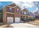 Two-story brick home with a two-car garage and a well-maintained lawn and manicured landscaping at 248 Allegrini Dr, Atlanta, GA 30349