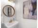 Bright powder room featuring a round mirror, stylish faucet, and modern decor at 1925 Woodland Hills Nw Ave, Atlanta, GA 30318