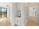 Hallway featuring white cabinets and trim, hardwood floors, and black hardware at 88 Whitehead Rd, Sugar Hill, GA 30518