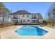 Backyard view of the pool, patio with seating, privacy fence, and meticulously maintained lawn at 88 Whitehead Rd, Sugar Hill, GA 30518