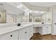 Bright bathroom with a double vanity, white cabinets, and large well lit mirror at 608 Chickory Ct, Woodstock, GA 30188