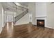 Bright living room with dark wood floors, fireplace, and staircase to the second floor at 608 Chickory Ct, Woodstock, GA 30188