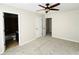 Carpeted bedroom showcasing an ensuite bathroom, ceiling fan, and neutral colors at 4425 Idlewood Dr, Cumming, GA 30040