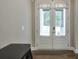 Bright entryway featuring wood floors, white trim, and a set of double doors leading to the backyard at 58 Cherry St, Lawrenceville, GA 30046