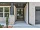 The covered front porch boasts brick columns and a gray front door, leading to a charming entrance at 58 Cherry St, Lawrenceville, GA 30046