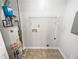 Utility room with water heater, tile flooring, and shelving, ideal for storage at 1487 Arnold Dr, Lawrenceville, GA 30043