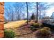 View of the backyard with mature trees, a sloping hill, and lush greenery at 3595 Mason Ridge Dr, Winston, GA 30187