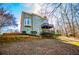 Exterior of home featuring a deck, bay window, and a beautifully landscaped backyard with trees at 3595 Mason Ridge Dr, Winston, GA 30187