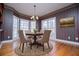 Dining area with a charming chandelier, round table with seating, and a set of large bay windows at 3595 Mason Ridge Dr, Winston, GA 30187