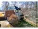 Rear view of a two-story house, featuring a brick and siding exterior, with a deck overlooking the yard at 3595 Mason Ridge Dr, Winston, GA 30187