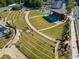 An aerial view features a grassy amphitheater with terraced seating and a central stage at 613 Everett Ln, Woodstock, GA 30188