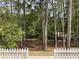 Green wooded view from backyard with white picket fence at 613 Everett Ln, Woodstock, GA 30188