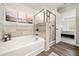 Beautifully tiled bath and shower with wood look flooring and decorative artwork at 613 Everett Ln, Woodstock, GA 30188