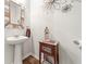 Charming powder room featuring pedestal sink, wood flooring, and decorative mirror at 613 Everett Ln, Woodstock, GA 30188