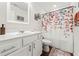 Bright bathroom featuring a single sink, a framed mirror, and a shower with floral shower curtain at 613 Everett Ln, Woodstock, GA 30188