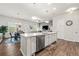 This open kitchen features a large center island with seating, stainless steel appliances and wood flooring at 613 Everett Ln, Woodstock, GA 30188