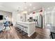 Bright, open kitchen featuring a large center island with seating, stainless steel appliances and wood flooring at 613 Everett Ln, Woodstock, GA 30188