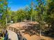 A playground features rope climbing structures, walkways, trees and wood chip ground cover at 613 Everett Ln, Woodstock, GA 30188