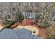 Aerial view of the property highlighting its lush landscaping, mulched yard, mature trees and proximity to a serene lake at 9135 Etching Overlook, Johns Creek, GA 30097