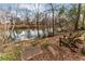 Scenic backyard featuring a serene riverside setting with wooden chairs for relaxation at 9135 Etching Overlook, Johns Creek, GA 30097