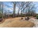 Lush backyard featuring a stone patio with outdoor seating and mature trees at 9135 Etching Overlook, Johns Creek, GA 30097