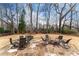 Picturesque backyard with stone patio, outdoor furniture, and mature trees at 9135 Etching Overlook, Johns Creek, GA 30097