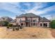 Beautiful brick home exterior featuring a stone patio, well-manicured lawn, and ample natural light at 9135 Etching Overlook, Johns Creek, GA 30097