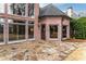 Charming brick home exterior featuring a stone patio and large windows for natural light at 9135 Etching Overlook, Johns Creek, GA 30097