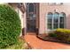 Elegant front entrance with brick walkway, decorative shrubs, and striking architectural details at 9135 Etching Overlook, Johns Creek, GA 30097