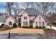 Charming two-story brick home with manicured lawn and mature landscaping at 9135 Etching Overlook, Johns Creek, GA 30097