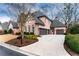 Spacious three-car garage and driveway, complemented by lush landscaping and a well-kept lawn at 9135 Etching Overlook, Johns Creek, GA 30097