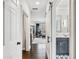 Hallway view showcasing hardwood floors, a glimpse of the living room, and a bathroom with navy vanity at 9135 Etching Overlook, Johns Creek, GA 30097