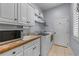 Well-equipped laundry room with ample cabinets, counter space, and modern appliances at 9135 Etching Overlook, Johns Creek, GA 30097