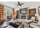 Cozy living room featuring a stone fireplace, built-in shelving, and plush seating at 9135 Etching Overlook, Johns Creek, GA 30097