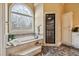 Bright main bathroom features a standalone tub and shower with intricate tile work at 9135 Etching Overlook, Johns Creek, GA 30097