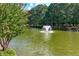 Community pond featuring a fountain, bordered by lush greenery and mature trees in a sunny area at 9135 Etching Overlook, Johns Creek, GA 30097