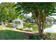 Picturesque view of a gazebo by a pond, surrounded by flowers and lush greenery, creating a peaceful escape at 9135 Etching Overlook, Johns Creek, GA 30097