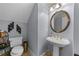 Stylish powder room with a pedestal sink, decorative mirror, and modern fixtures at 9135 Etching Overlook, Johns Creek, GA 30097