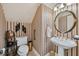 Elegant powder room featuring a pedestal sink, decorative mirror, and striped wallpaper at 9135 Etching Overlook, Johns Creek, GA 30097