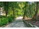 Picturesque wooded walking path lined with trees and lush vegetation through the neighborhood at 9135 Etching Overlook, Johns Creek, GA 30097