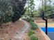 Picturesque backyard featuring a stone pathway, lush garden beds, and a glimpse of the basketball court at 3553 Old Maple Dr, Johns Creek, GA 30022