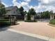 Gated entrance to the community featuring brick pillars, wrought iron gates, and well-maintained landscaping at 3553 Old Maple Dr, Johns Creek, GA 30022