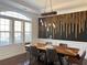 Stunning dining room with custom wood accent wall, modern chandelier, and large window at 3553 Old Maple Dr, Johns Creek, GA 30022