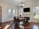 Dining room with a modern table, chairs, fireplace, and natural light from large windows at 3553 Old Maple Dr, Johns Creek, GA 30022