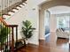 Inviting foyer with hardwood floors, staircase, bench, and view into the living room at 3553 Old Maple Dr, Johns Creek, GA 30022