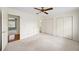 Bright, carpeted bedroom featuring a ceiling fan and access to an ensuite bathroom and closet at 810 Towergate Pl, Atlanta, GA 30350