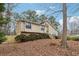 Exterior view of the home showing the sloped front yard and mature trees at 6664 Windwood Cir, Douglasville, GA 30135
